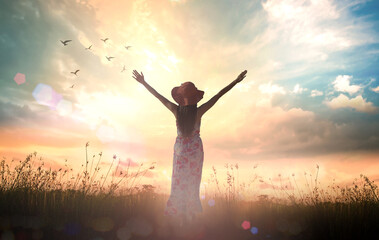 International women's day concept: Silhouette of healthy woman raised hands for praise and worship God at autumn sunset meadow background - obrazy, fototapety, plakaty