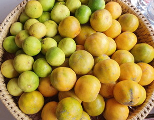Organic Tangerine and lime are placed in a basket to produce fruit juices.Oranges have a sweet and sour taste and lemons have a sour taste.This fruit is high in vitamin C,which helps prevent colds 
