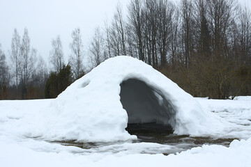 Housem eskimos igloo or yurt made by children from snow in a thaw in winter day.
