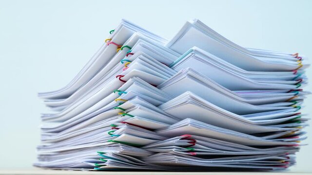 4K Stop motion of close-up stack overload document report paper with paperclip place increases and decrease on green background, business and education concept footage paperless used. 