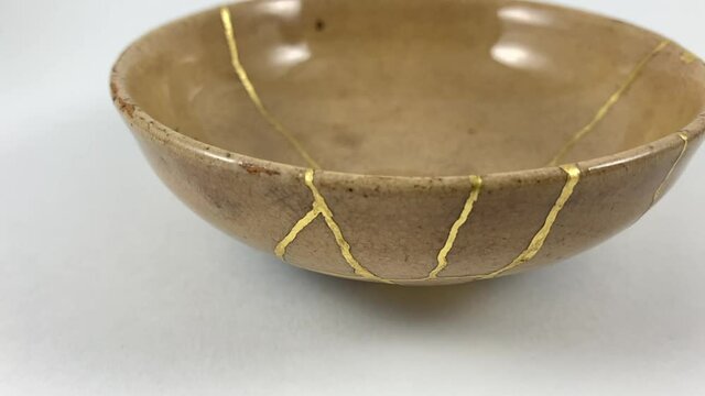 Antique broken Japanese beige bowl repaired with gold kintsugi technique