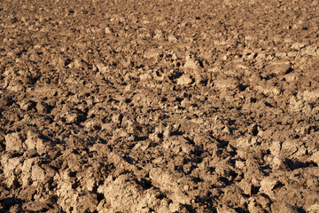 Close up of plowed earth, the nutritious soil is used to grow field crops and food. Pattern.