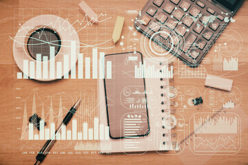 Multi exposure of forex graph hologram over desktop with phone. Top view. Mobile trade platform...