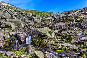 Fototapeta na wymiar stream cascades flowing over the rocks in the mountains