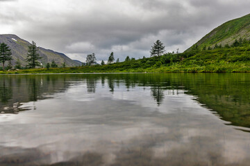 Fototapeta premium cold lake in the mountains on a cloudy summer day