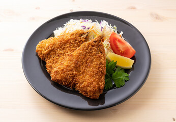 Fried horse mackerel served on a plate on a wooden background