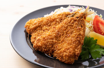 Fried horse mackerel served on a plate on a wooden background