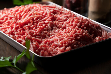 Minced meat in a tray on a wooden background