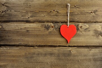 Red heart on a  old vintage wooden wall isolated close up. The concept of love and heart warmth.Valentine's Day background