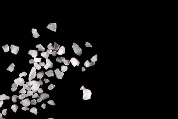 Crystals of sea salt isolated on black background. Free space for an inscription.