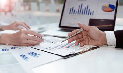 A group of professional business people sit on a meeting table in the office to discuss banking issues. Share partner A meeting idea that talks about a graph