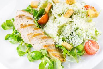 Caesar salad with chicken on a white plate