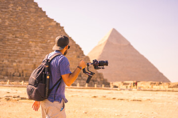 A young photographer at the pyramid of Cheops the largest pyramid. The pyramids of Giza the oldest...