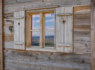 Ein Holzhaus mit Fenster und Fensterläden aus Holz