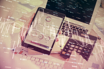 Double exposure of man's hands holding and using a digital device and forex graph drawing. Financial market concept.