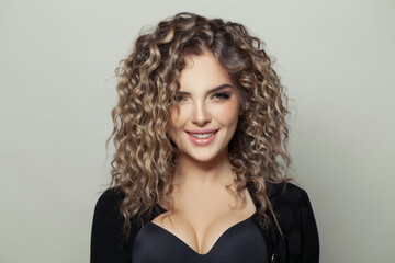 Happy woman with curly hair smiling on white background