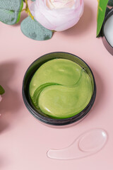 green tea eye patches to reduce puffiness and bruising under the eyes. flatlay. the view from the top on a pink background. the concept of self-care