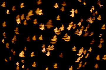 Abstract glitter defocused blinking christmas tree and sparks on black background. Christmas and New Year holidays template