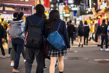 渋谷センター街を歩く制服の高校生カップルの後ろ姿