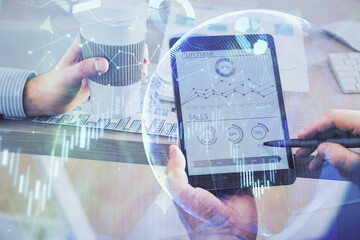 Double exposure of man's hands holding and using a phone and financial chart drawing. Market analysis concept.