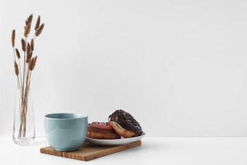 Mug and donuts cakes on a white background. Confectionery, coffee shop. Copy space, mock up.