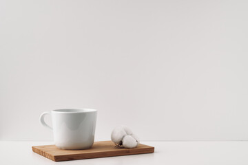 White cup and cotton on a board, cork background. Mock up, copy space. Folk