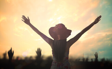 Praise and worship God concept: Silhouette woman raised hands over autumn sunset background