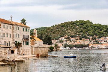 Fototapeta na wymiar View of the gulf with medieval houses, cathedral and motor boats near the island of Vis, Croatia