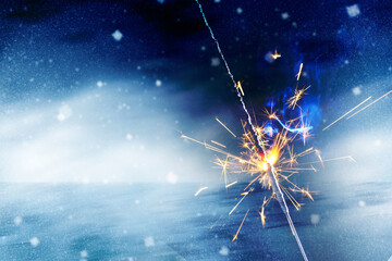 Happy New Year Burning sparkler in female hand on background of christmas tree with lights