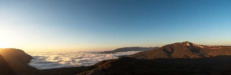 Panorama of mountains and clouds above the horizon. Mountain morning landscape.