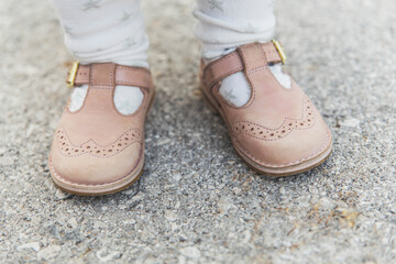 Baby feet shod in brown leather sandals
