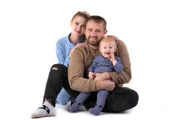 Over white background happy dad mom with one-year-old toddler smiling and looking at the camera.