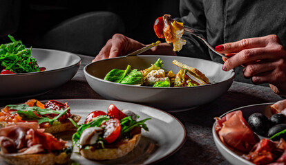woman eating healthy salad from bowl sitting in cafe