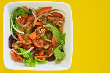salad plate on yellow background. Healthy vegetarian food. Space for text