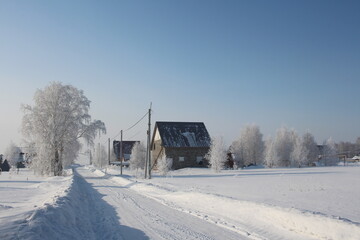 winter in Siberia snow white road in snowdrifts beautiful houses in the village of rime