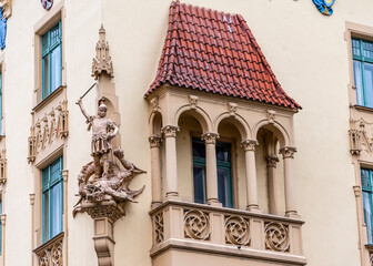 Fragment of a building with a medieval warrior sculpture and a balcony in Prague, Czech Republic