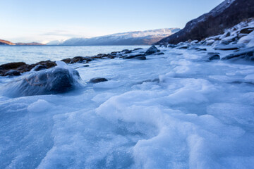 Beautiful winter landscape with icy shore of the fjord