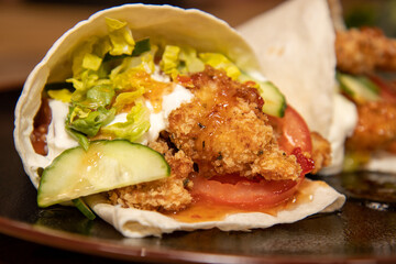 Delicious sizzling chicken fajitas with guacamole and sour cream on a wooden kitchen work top