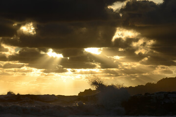 Sun rays at sunset with storm wave.
