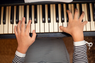 Top view of a pianist girl playing the old piano, preparing for classes in the musical school. Learning to play the piano