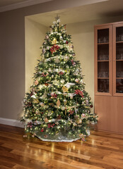 Carefully and beautifully decorated xmas tree in the corner of a modern home with wooden floors