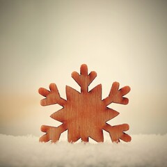 Christmas background. Christmas tree decoration - beautiful natural wooden snowflake with real snow. Background for winter and holiday.