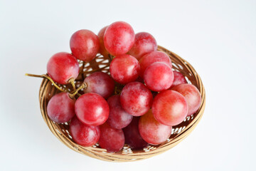 Red grape in an old basket on white background