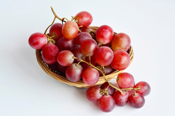Red grape in an old basket on white background