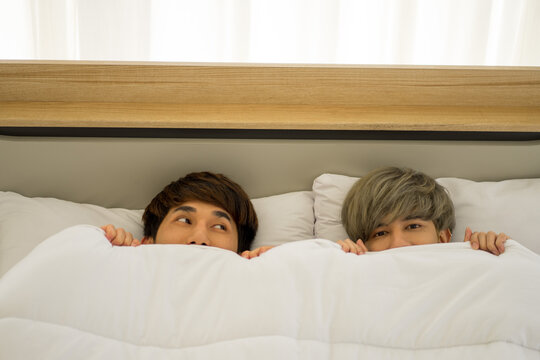 Asian men same sex love marriage LGBTQ on bed during holiday having good time. 