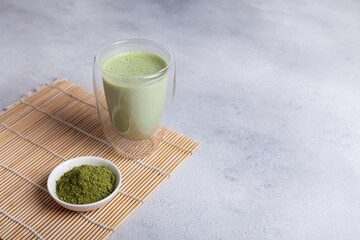 Matcha with milk in a glass on a light background