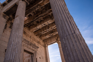 Naklejka premium Ancient ruins of Propylaia or Propylaea, Acropolis, Athens, Greece. It is monumental gateway to the Acropolis, next to the Parthenon. Photo of iconic pillars and Greek arhitecture with beautiful sky.