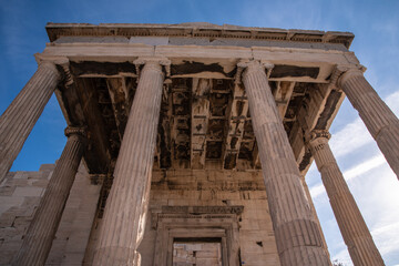 Obraz premium Ancient ruins of Propylaia or Propylaea, Acropolis, Athens, Greece. It is monumental gateway to the Acropolis, next to the Parthenon. Photo of iconic pillars and Greek arhitecture with beautiful sky.