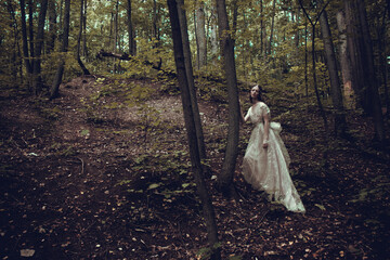 Fototapeta premium Portrait of a woman in a forest. Space for text. The concept of fashion. Magic fabulously fairytale photo. bride in nature