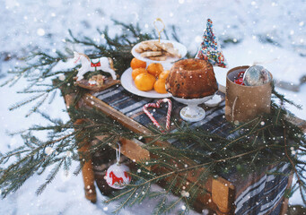 Fototapeta na wymiar Tangerines, cupcakes, cookies, Christmas toys, spruce branches on the table.
